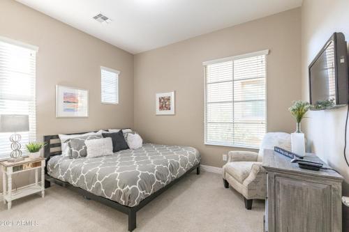1 dormitorio con 1 cama, 1 silla y ventanas en Villa Princess townhouse, en Scottsdale