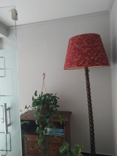 a lamp sitting next to a plant next to a wall at Elaėa Boutique Apartments in Piraeus