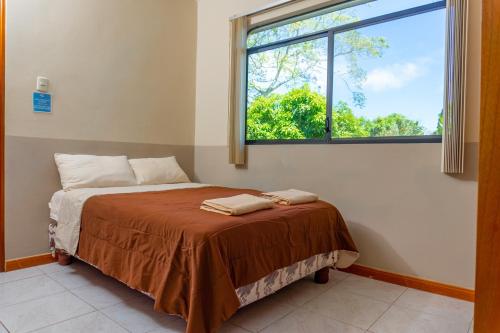 una camera da letto con un letto e una grande finestra di Cucuve Eco Hostal a Puerto Baquerizo Moreno