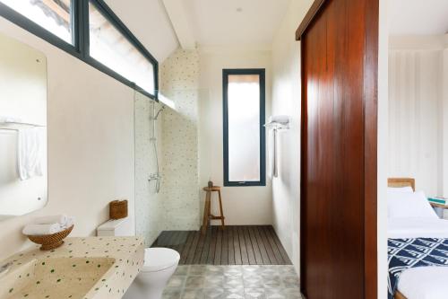 Zimmer mit einem Bad mit WC und Waschbecken in der Unterkunft Contemporary Artisanal Studio Apartment in Ubud in Ubud