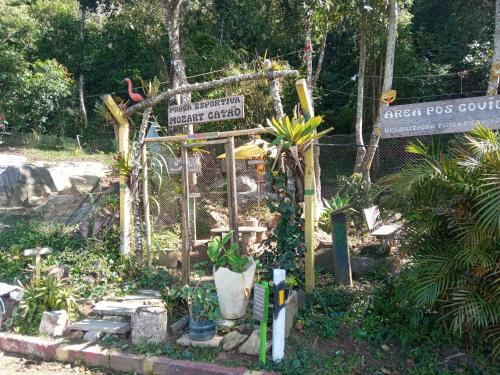 ein Garten mit Straßenschild und einigen Pflanzen in der Unterkunft Conjugado Aconchegante em Teresópolis in Teresópolis