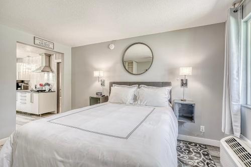 a large white bed in a room with a mirror at Lighthouse Kitchen Suites near Auburn Waterloo I-69 Exit 334 in Auburn