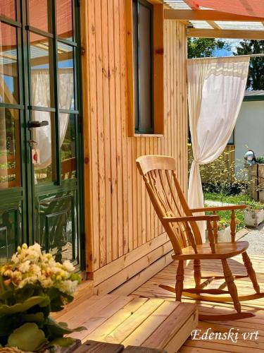 a wooden rocking chair sitting on a wooden deck at Edenski vrt in Ivančna Gorica