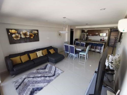 a living room with a couch and a dining room at APARTAMENTO CON ALBERCA en Mazatlán in Mazatlán