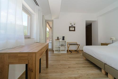 a bedroom with a bed and a desk and a window at Relais Chalons d’Orange in Pescasseroli