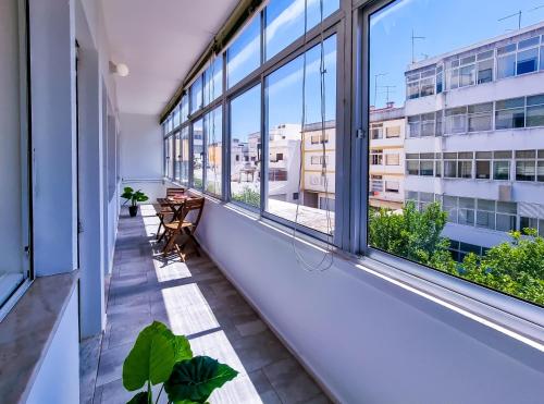 an apartment balcony with windows and plants at FLH Loulé Balcony Spacious Apartment in Loulé