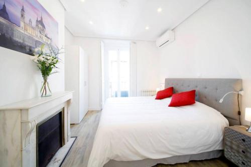una camera da letto bianca con letto bianco e cuscini rossi di Luxury & Design Apartment Madrid Center 3BRM 3BTHR a Madrid