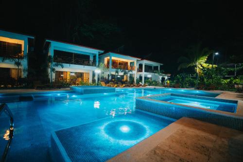 a swimming pool at night with a house at Bungalows Punta Uva in Punta Uva