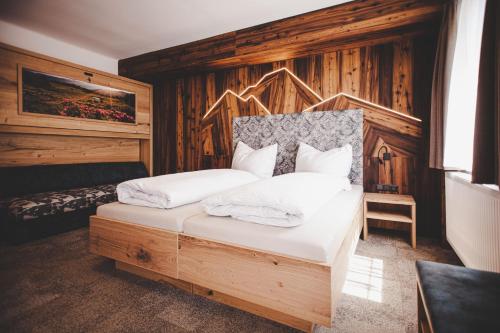um quarto com uma cama com lençóis e travesseiros brancos em Gasthof Gschoadwirt em Kernhof