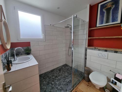 ein Bad mit einer Dusche, einem WC und einem Waschbecken in der Unterkunft Le Crocolion in Arès