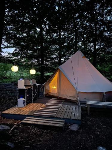 a tent with a wooden deck with a desk in it at Naturglamping in Kristianstad