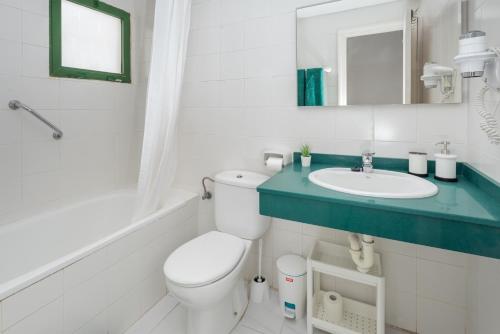 a white bathroom with a toilet and a sink at Lanzahost Casa Cala in Costa Teguise