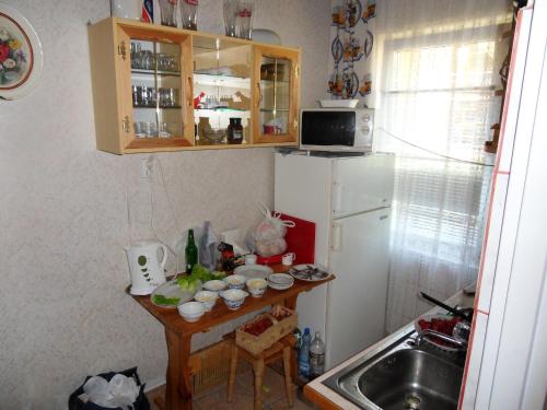 a small kitchen with a table and a refrigerator at Blizniak nad Morzem in Rowy