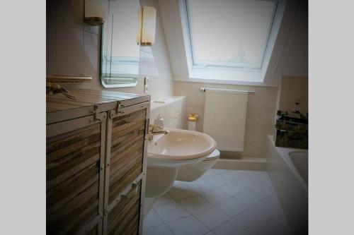 a bathroom with a sink and a toilet and a window at MaNaLa "120 m2" in Algolsheim