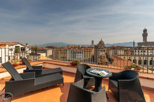 a balcony with chairs and a view of a city at B&B Hotel Firenze Pitti Palace al Ponte Vecchio in Florence