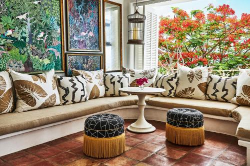 a living room with a couch and two stools at Malliouhana Resort Anguilla in Meads Bay