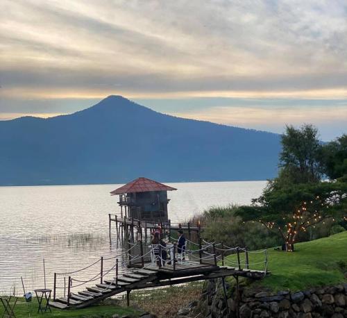 two people sitting on a dock in the water at Hacienda Ucazanaztacua in Pátzcuaro