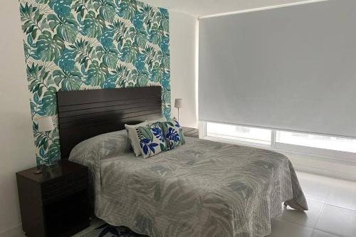 um quarto com uma cama com papel de parede floral em A estrenar, Vista al mar en Torre Bellagio con amenities em Punta del Este