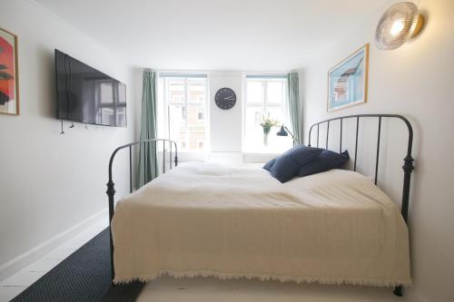 a bedroom with a bed and a tv and a window at Latin Quater 1 - 4 in Copenhagen