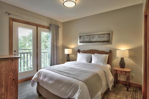a bedroom with a large bed and a balcony at Blue Mountain Resort Home Collection in Blue Mountains