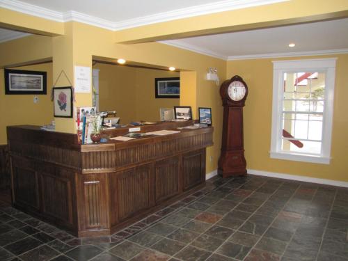 a reception desk with a clock in a salon at Grenfell Heritage Hotel & Suites in St. Anthony