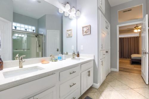 a bathroom with two sinks and a large mirror at Casa Palmera in Panama City Beach