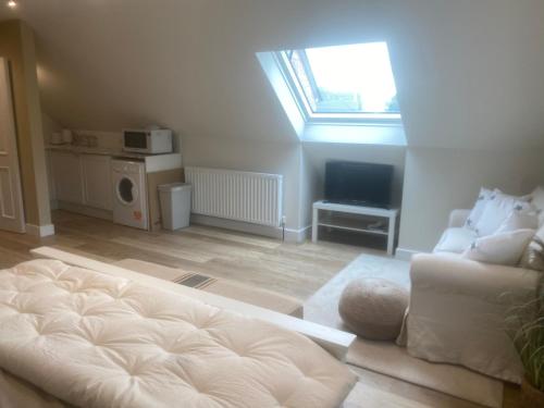 a living room with a white couch and a window at Nettleford in Kelsall