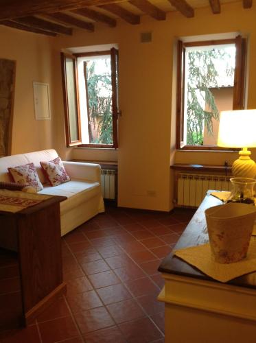 a living room with a couch and two windows at Pinturicchio, Characteristic and comfortable apartment in the historic center in Perugia