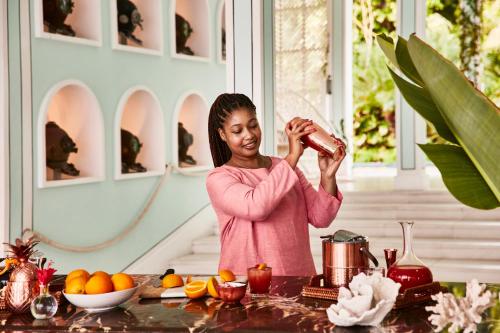 a woman standing in a kitchen pouring something into a kettle at Malliouhana Resort Anguilla in Meads Bay
