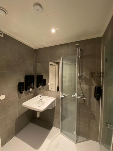 une salle de bain avec un lavabo et une douche dans l'établissement Finnvikhaugen Rooms, à Meistervik