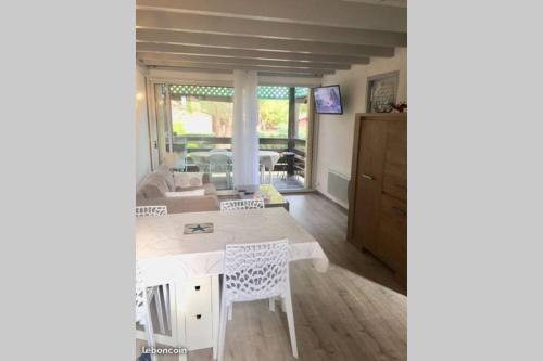 une cuisine et un salon avec une table et des chaises dans l'établissement Appartement tout confort proche plage, à Moliets-et-Maa