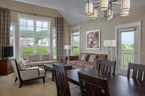 a living room with a table and chairs and a couch at Blue Mountain Resort Home Collection in Blue Mountains