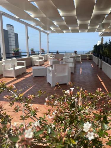 - un balcon avec des chaises et des tables blanches dans un bâtiment dans l'établissement La Terrazza degli Dei, à Buonvicino