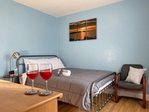 una camera da letto con due bicchieri di vino rosso su un tavolo di 2 BR Apt near Great Lakes Naval Base and 6 Flags a Waukegan