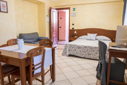 a bedroom with a bed and a table and chairs at Residence Alberghiero Eolie in Lipari