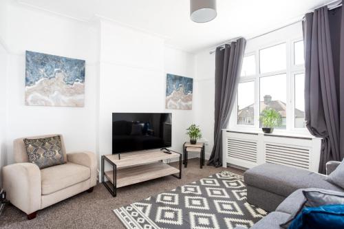 a living room with a couch and a tv at The Woodgrange by Sorted Stay in Southend-on-Sea