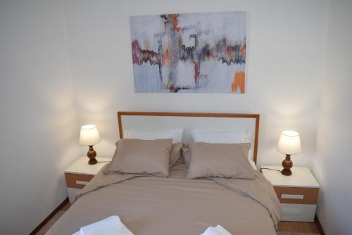 1 dormitorio con 1 cama con 2 lámparas en ambos lados en Terreiro da Erva House, en Coímbra