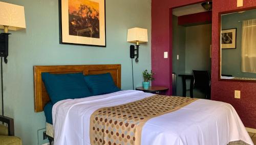 1 dormitorio con 1 cama grande y paredes azules y rojas en Copper Mountain Motel, en Superior