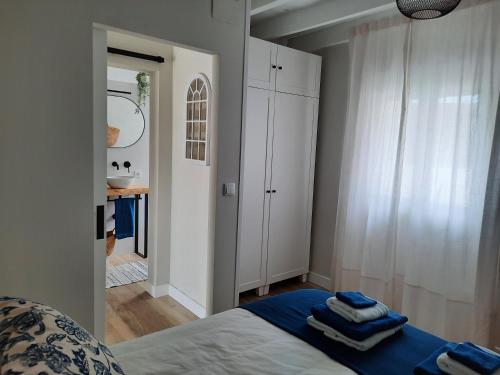 1 dormitorio con 1 cama con toallas en VIVIENDA VACACIONAL LA PERILLANA. Entre lo rural y lo urbano, en Avilés