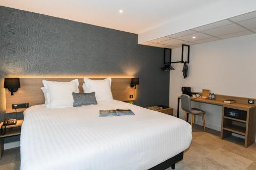 a bedroom with a large white bed and a desk at Best Western Plus Le Havre Centre Gare in Le Havre
