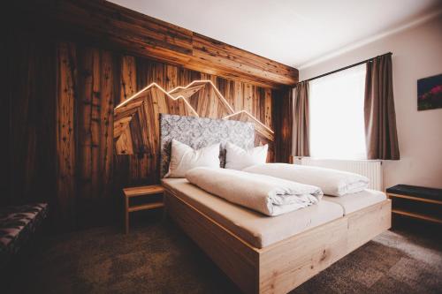 um quarto com uma cama com uma parede de madeira em Gasthof Gschoadwirt em Kernhof