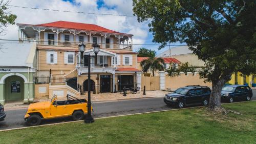 a yellow truck parked in front of a building at Victoria House in Frederiksted