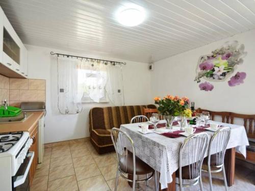 a kitchen with a table with chairs and flowers on it at Willa u Bogusi- 8 minut od plaży in Dźwirzyno