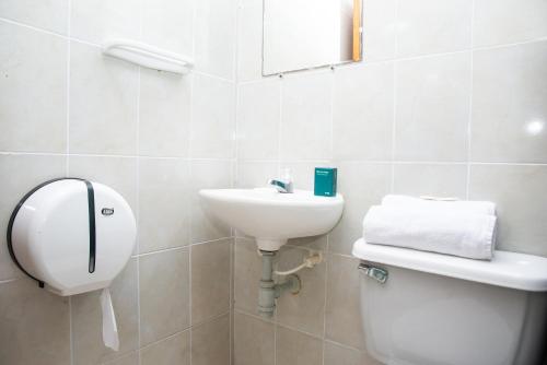 W łazience znajduje się umywalka, toaleta i lustro. w obiekcie Ayenda Puerto Colombia w mieście Puerto Colombia