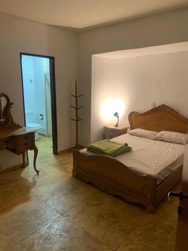 a bedroom with a bed and a table and a lamp at Pousada Casa do Fabio - Bikers point in Águas da Prata