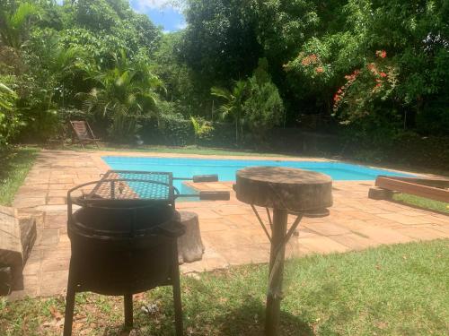 a grill and smoker next to a swimming pool at Pousada Casa do Fabio - Bikers point in Águas da Prata