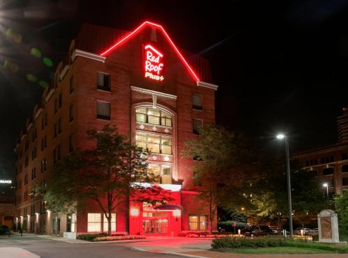 a building with a red neon sign on it at Red Roof Inn PLUS+ Columbus Downtown - Convention Center in Columbus