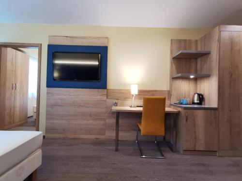 a room with a desk with a chair and a tv at Alpengasthof Tanzstatt in Lachtal