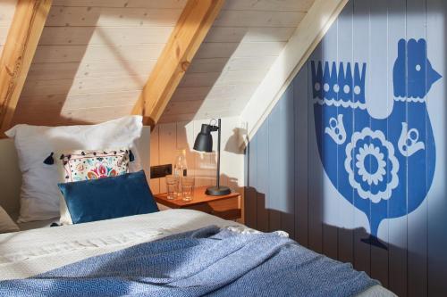 a bedroom with a bed with a blue wall at Siedlisko Wnukowo in Szczechy Małe