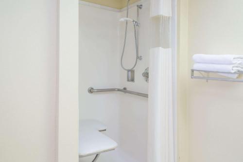 a bathroom with a shower with a toilet and towels at Days Inn by Wyndham Sanford in Sanford
